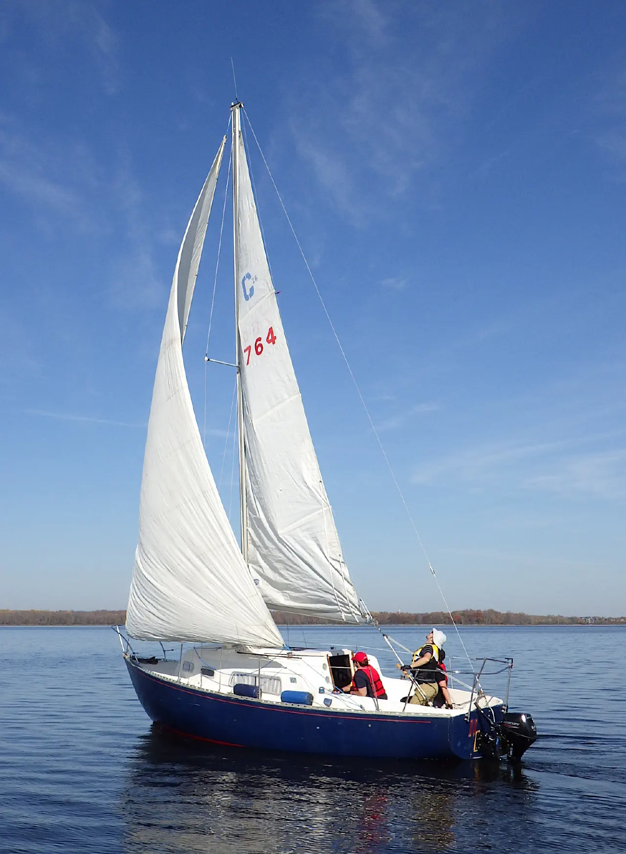 Sailboat Slowpoke on calm blue water under a clear sky. Photo by Adam Hunt.